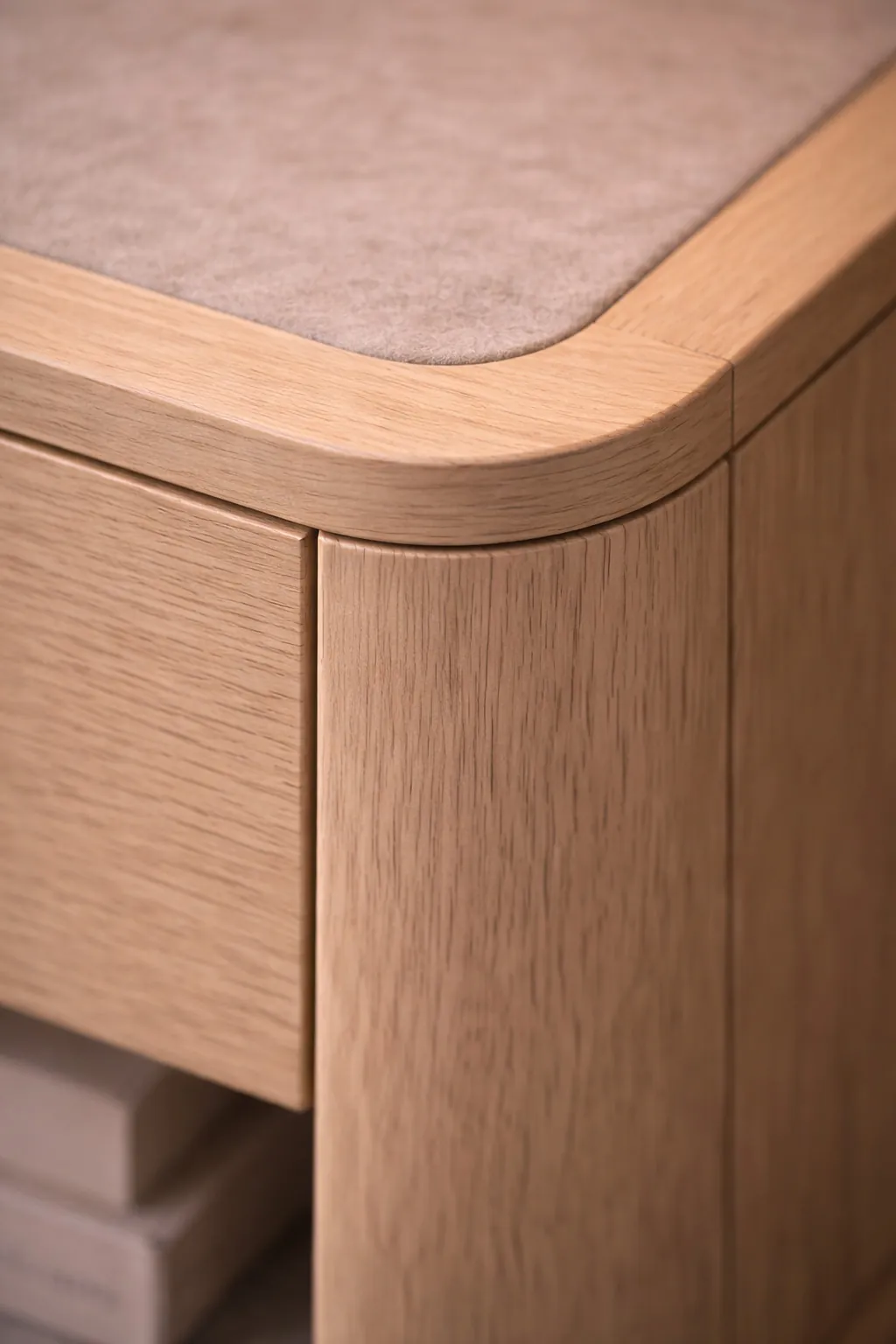 Close-up of softly curved oak edge meeting a felt-lined surface